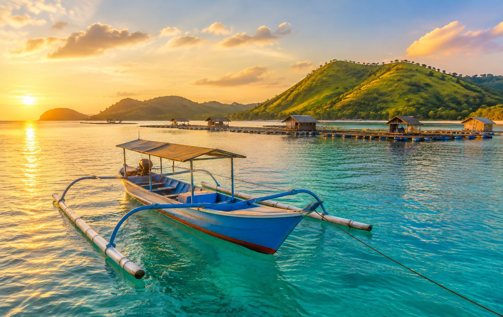 Blue outrigger boat in Ekas Bay at sunrise
